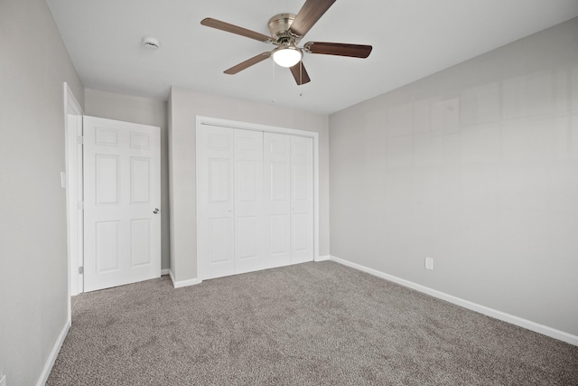 unfurnished bedroom featuring a closet, carpet flooring, a ceiling fan, and baseboards