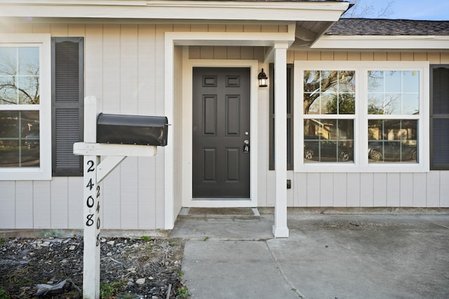 entrance to property with a shingled roof