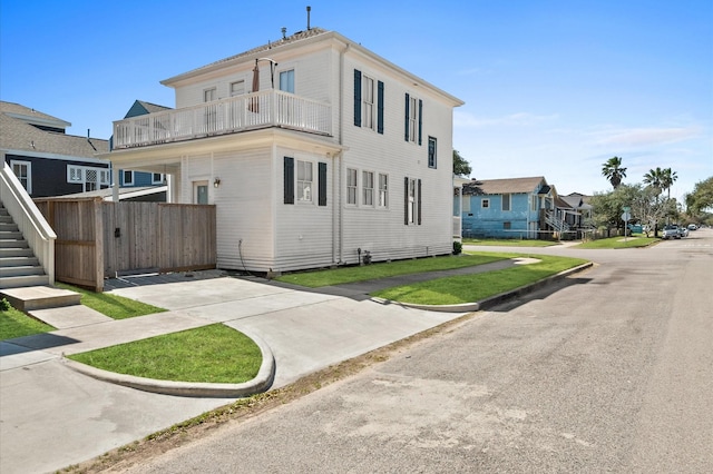 view of front of property with a residential view, stairway, and a balcony