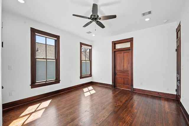 empty room featuring hardwood / wood-style floors, recessed lighting, baseboards, and visible vents