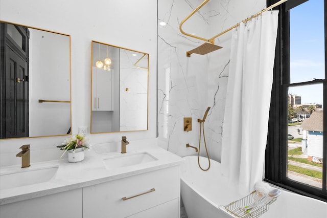 bathroom with a sink, a marble finish shower, a freestanding bath, and double vanity