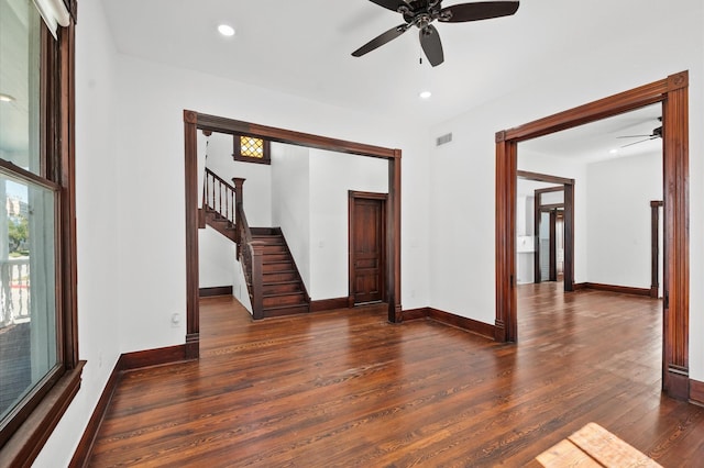 empty room featuring wood finished floors, visible vents, baseboards, recessed lighting, and stairs