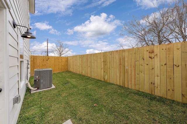 view of yard with central air condition unit and fence