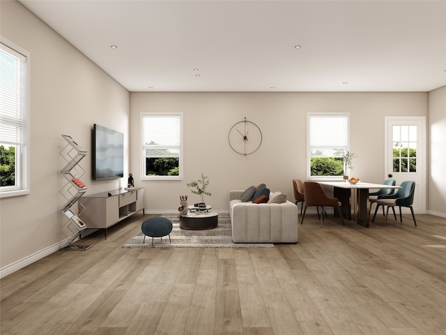 living area with plenty of natural light, recessed lighting, baseboards, and light wood finished floors