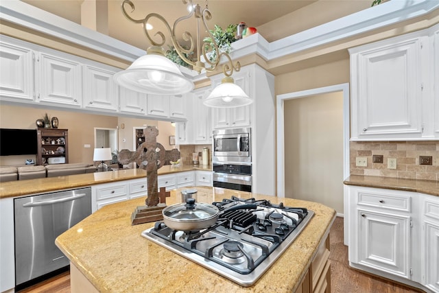 kitchen with a kitchen island, white cabinetry, stainless steel appliances, and decorative backsplash