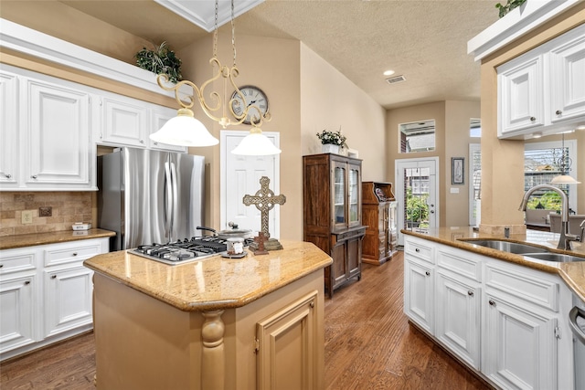 kitchen with a sink, visible vents, dark wood-style flooring, and stainless steel appliances