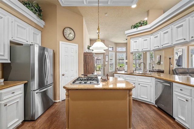 kitchen featuring a center island, stainless steel appliances, dark wood-style floors, white cabinetry, and a sink