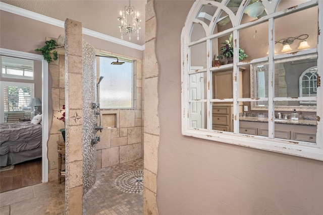 ensuite bathroom with walk in shower, a chandelier, vanity, ornamental molding, and ensuite bath