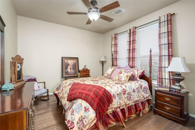 bedroom with a ceiling fan, wood finished floors, visible vents, and baseboards