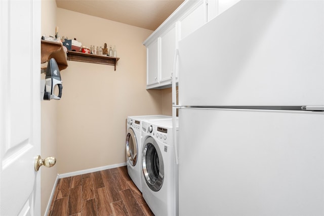 clothes washing area with baseboards, cabinet space, independent washer and dryer, and dark wood finished floors