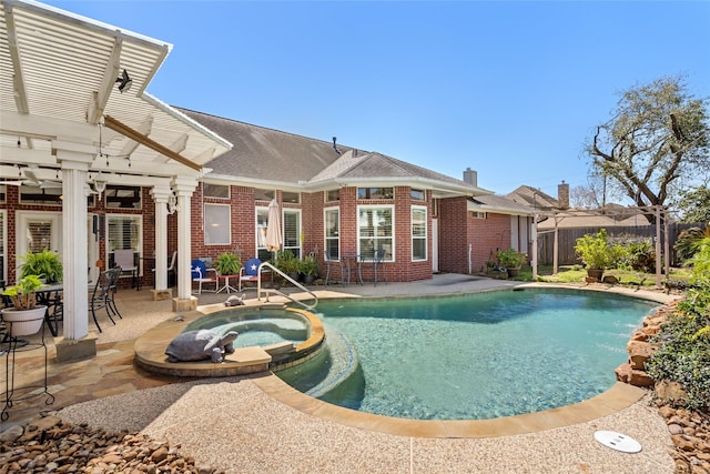 view of pool with a patio area, a pool with connected hot tub, a pergola, and fence