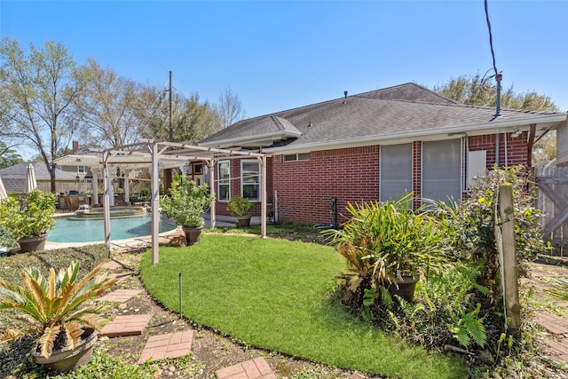 back of house with brick siding, a lawn, a pergola, and fence