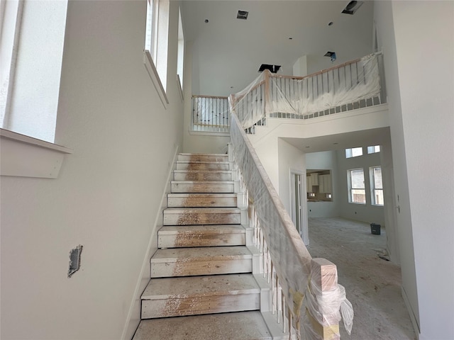 staircase with visible vents and a high ceiling