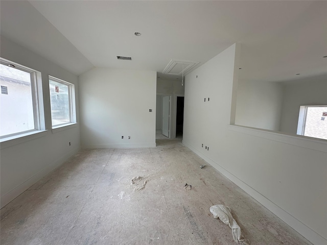 empty room with attic access, visible vents, and vaulted ceiling