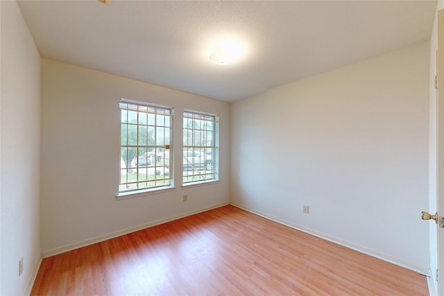 empty room featuring light wood-style flooring and baseboards