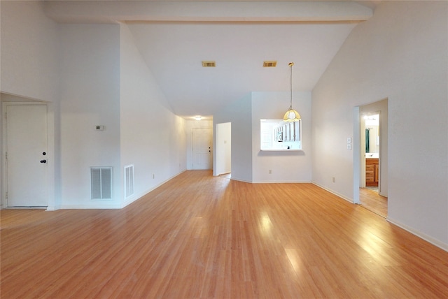 unfurnished living room with visible vents, baseboards, high vaulted ceiling, and light wood finished floors