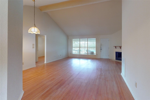 unfurnished living room with a fireplace with flush hearth, high vaulted ceiling, beam ceiling, light wood finished floors, and baseboards