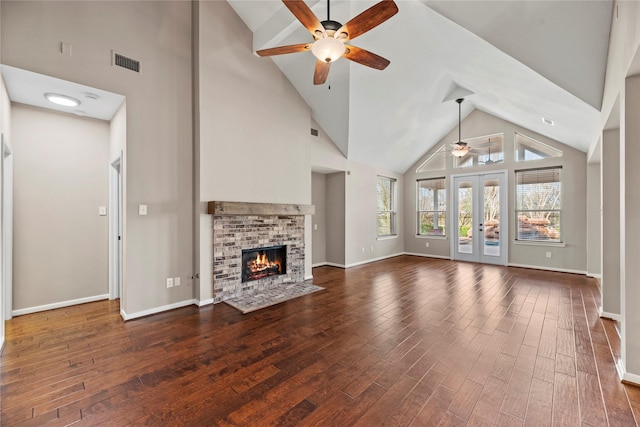 unfurnished living room featuring visible vents, ceiling fan, french doors, a fireplace, and wood finished floors