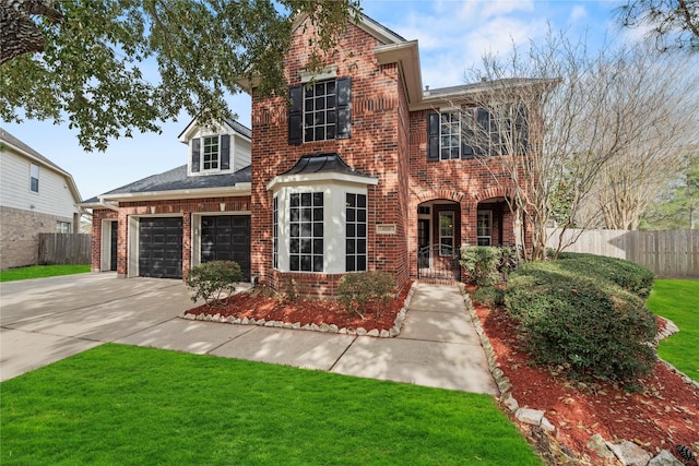 traditional-style house with concrete driveway, fence, brick siding, and a front lawn