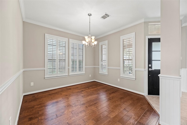 unfurnished dining area featuring visible vents, an inviting chandelier, ornamental molding, and hardwood / wood-style flooring