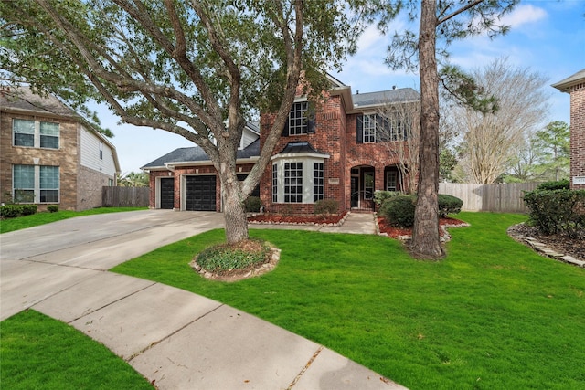 traditional-style home with driveway, fence, a front yard, an attached garage, and brick siding