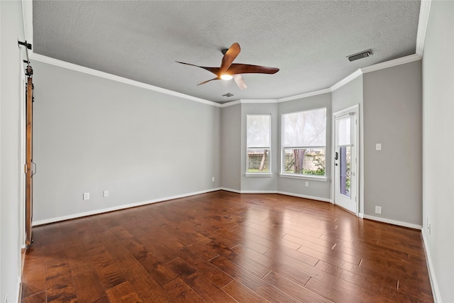 spare room with visible vents, baseboards, ceiling fan, a barn door, and wood finished floors