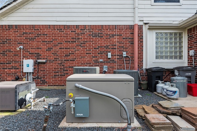 details featuring central air condition unit and brick siding