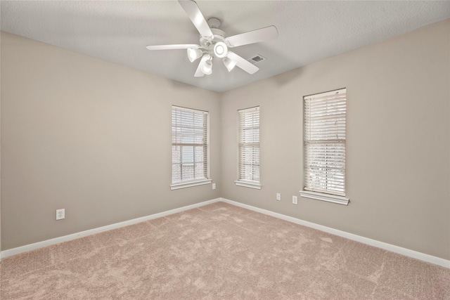 empty room featuring visible vents, baseboards, ceiling fan, and carpet flooring