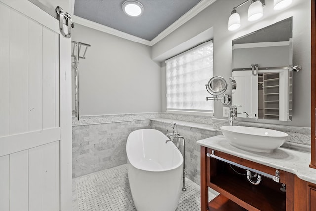 full bathroom featuring a wainscoted wall, ornamental molding, a freestanding tub, tile patterned floors, and vanity