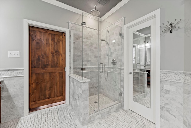 full bath with crown molding, tile walls, visible vents, and a stall shower