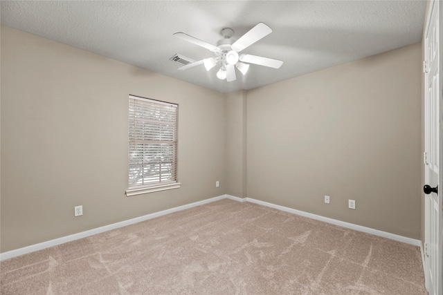 carpeted spare room featuring a textured ceiling, a ceiling fan, visible vents, and baseboards