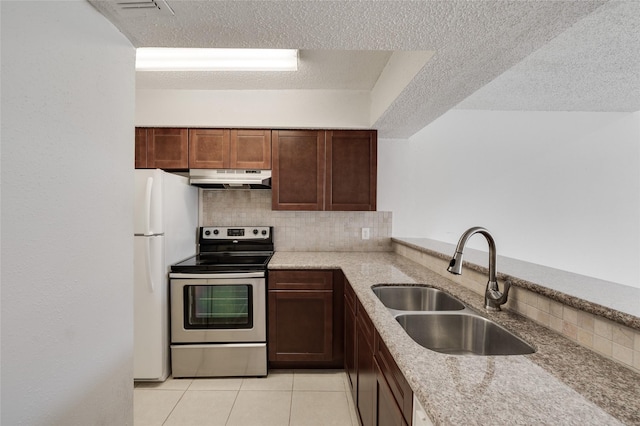 kitchen featuring electric range, under cabinet range hood, a sink, backsplash, and freestanding refrigerator