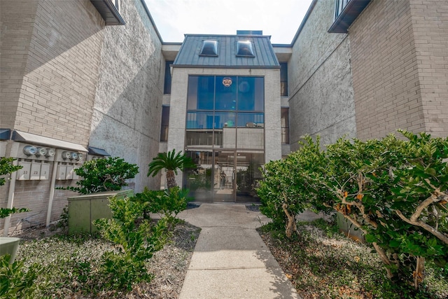 doorway to property featuring stucco siding, metal roof, and a standing seam roof