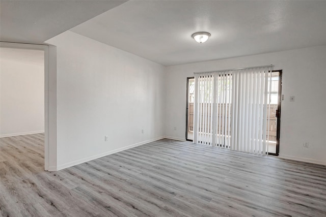 empty room with baseboards and wood finished floors