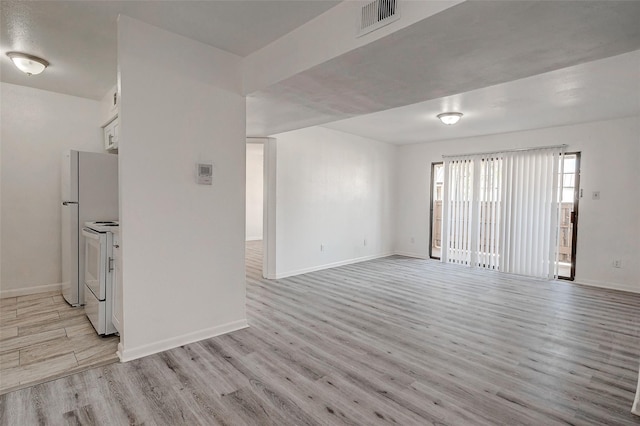 interior space featuring light wood-style flooring, baseboards, and visible vents
