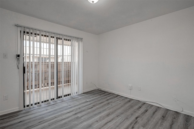 empty room with baseboards and wood finished floors