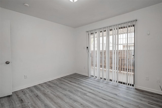unfurnished room with baseboards and wood finished floors