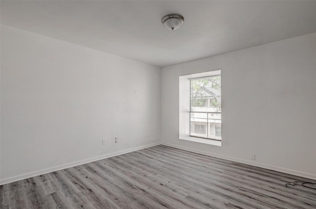 unfurnished room featuring wood finished floors and baseboards