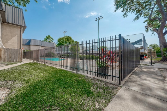 view of swimming pool with a yard and fence