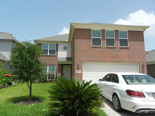 traditional home featuring a front lawn, an attached garage, brick siding, and driveway