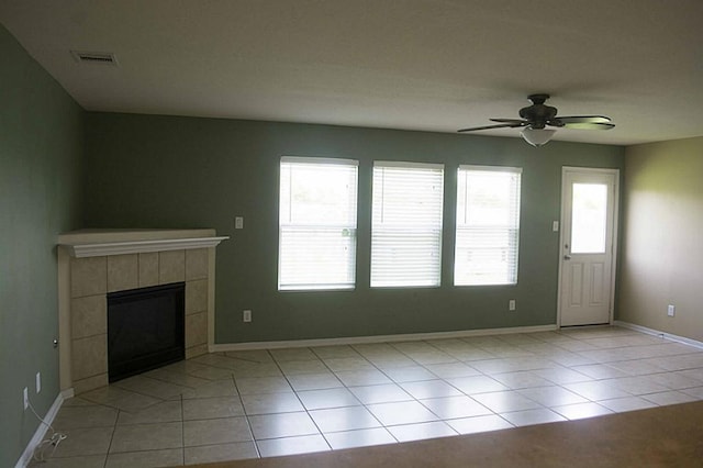 unfurnished living room with light tile patterned floors, visible vents, a fireplace, and a wealth of natural light