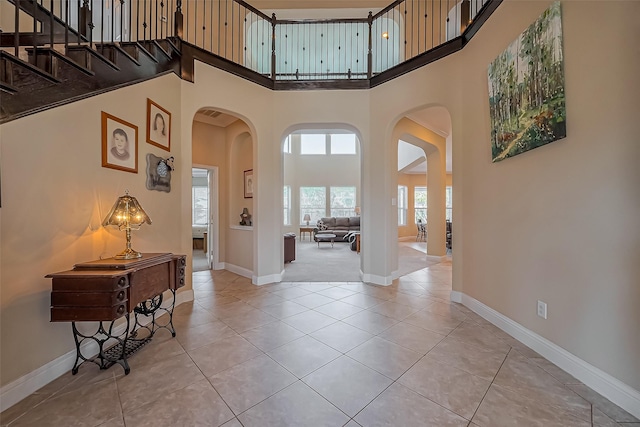 foyer featuring baseboards and arched walkways