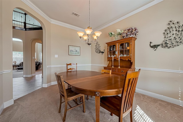 dining room with visible vents, arched walkways, light carpet, crown molding, and a chandelier