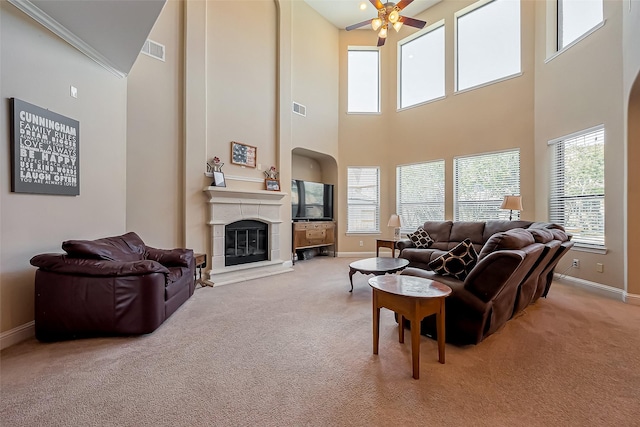 carpeted living room featuring visible vents, baseboards, a large fireplace, and ceiling fan