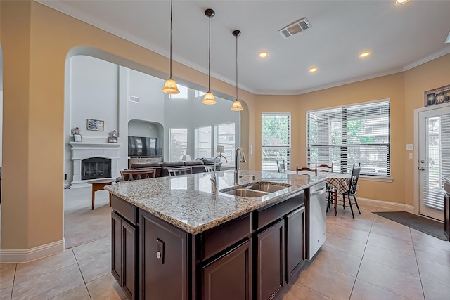 kitchen featuring light tile patterned floors, visible vents, a sink, dark brown cabinets, and stainless steel dishwasher