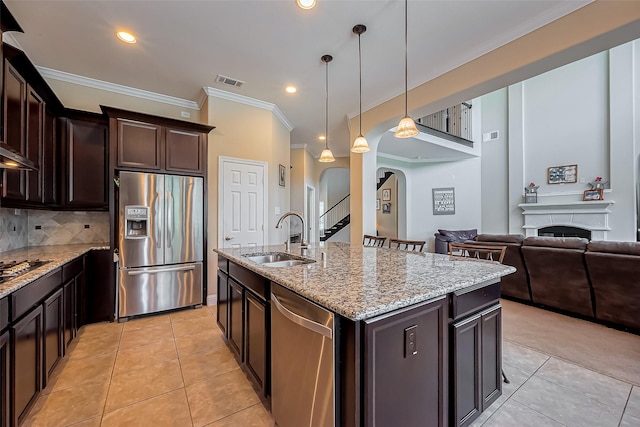 kitchen with visible vents, arched walkways, a sink, decorative backsplash, and appliances with stainless steel finishes