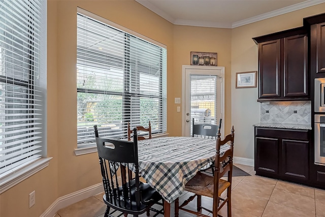 dining area featuring light tile patterned flooring, baseboards, and ornamental molding