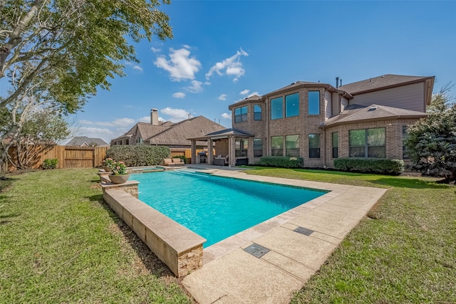 view of pool featuring a patio area, a yard, a fenced backyard, and a pool with connected hot tub