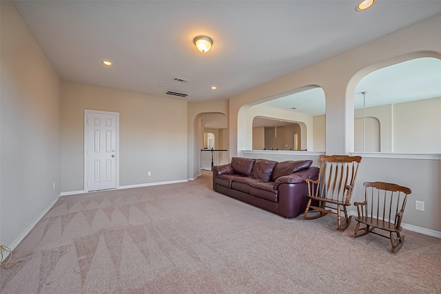 living area with visible vents, recessed lighting, arched walkways, carpet floors, and baseboards