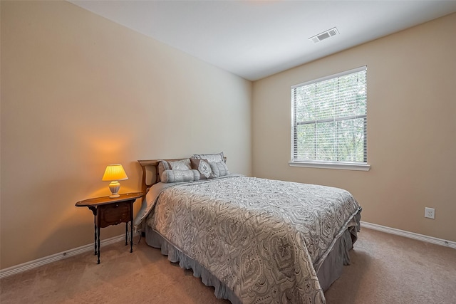 bedroom featuring visible vents, light colored carpet, and baseboards